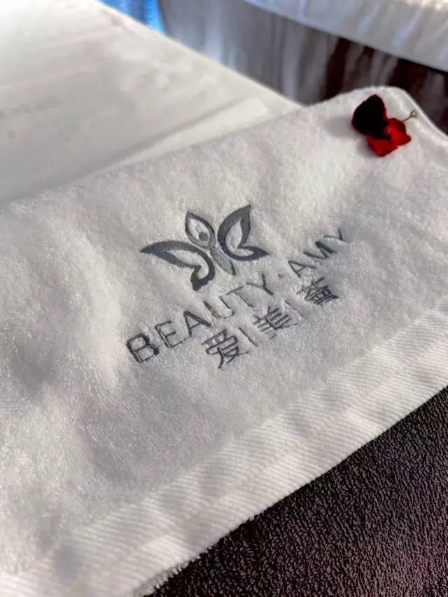 Il logo Beauty Amy ricamato su un asciugamano bianco